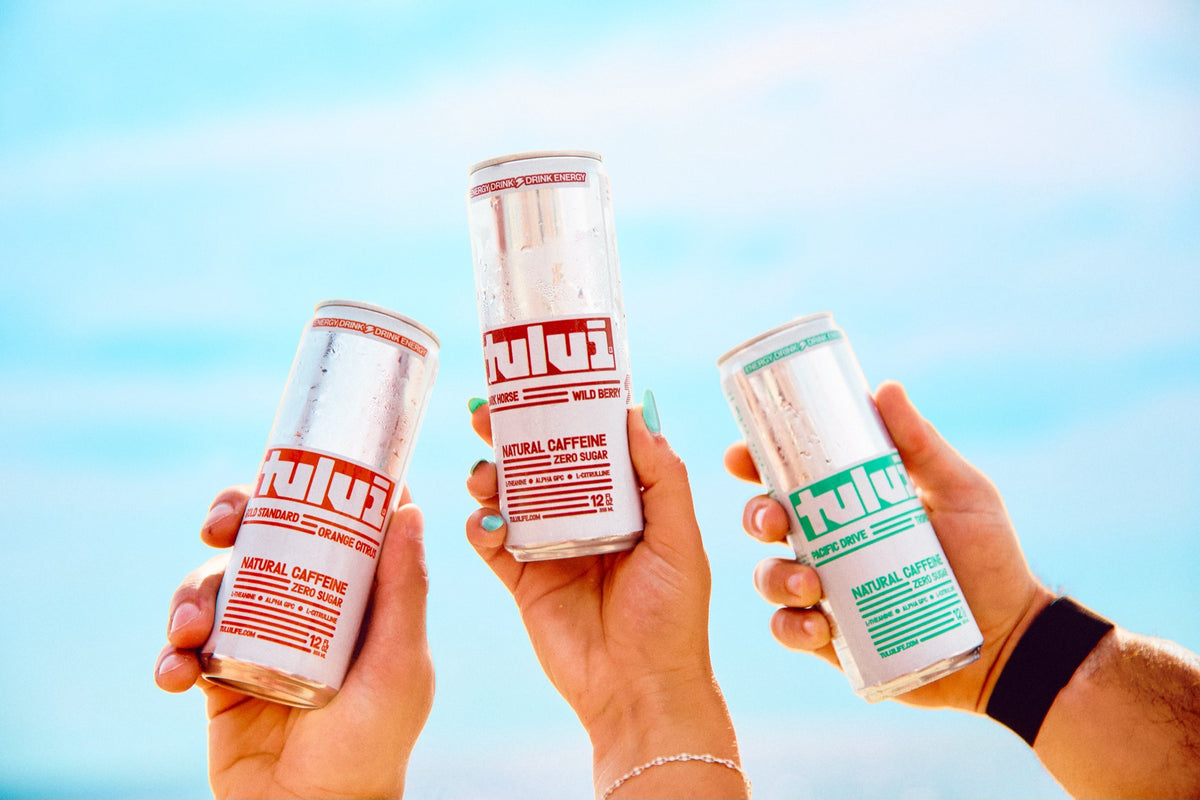 Three TULUI cans raised to the sky